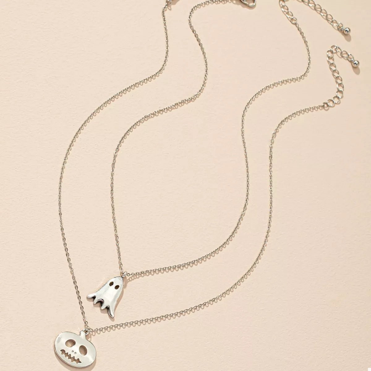 Two-piece silver ghost-and-pumpkin necklace set included in the bundle